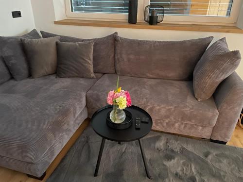 a couch with a table with a vase of flowers on it at Apart Christine in Brixlegg