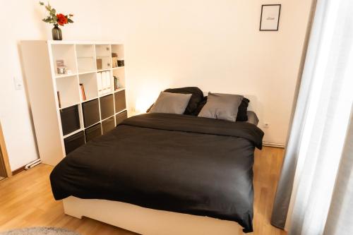 a bedroom with a bed with a black blanket at M House Ruhiges Einzelzimmer mit Privatsphäre für 1-2 Personen in Hagen