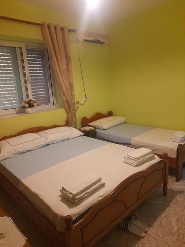 dwa łóżka w pokoju z dwoma oknami w obiekcie Flor Apartament w Sarandzie