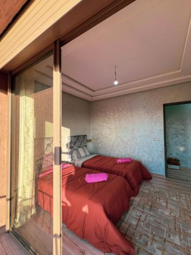 two beds in a room with a window at Ourika Luxury Villa in Ourika