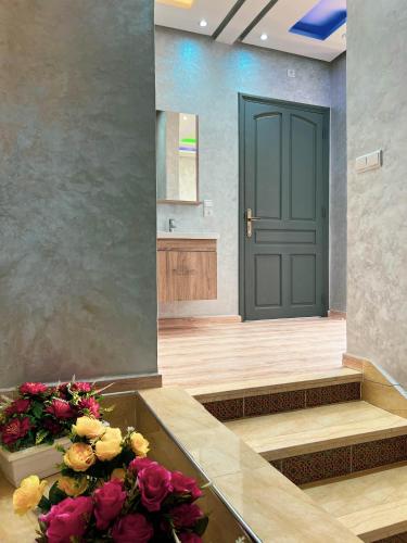 a lobby with a green door and flowers on the stairs at Ourika Luxury Villa in Ourika