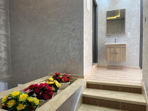 a bathroom with a sink and flowers on a counter at Ourika Luxury Villa in Ourika