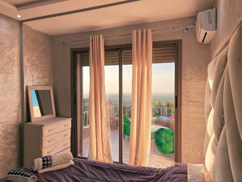 a bedroom with a bed and a large window at Ourika Luxury Villa in Ourika