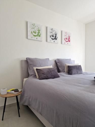 a white bedroom with two beds and a table at Seaview234 in Middelkerke