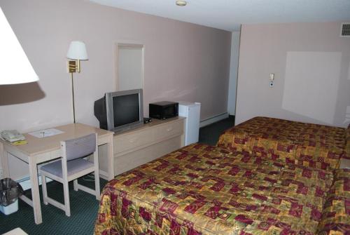 a hotel room with a bed and a desk and a tv at National 9 Inn Showboat in Casper