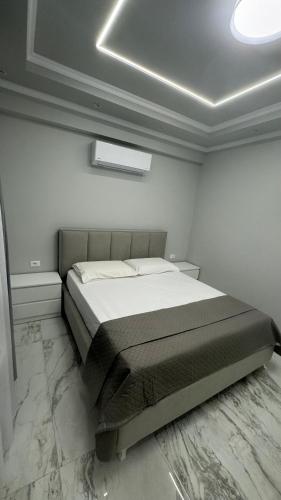 a bedroom with a bed in a white room at Ada Apartment Hilltop Serenity in Durrës