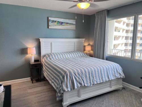a bedroom with a white bed and a window at Beach, Sand, Sun & Pool 2BR 2BA Condo in Panama City Beach