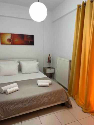 a bedroom with a bed with two towels on it at Cozy apartment in Thérissos