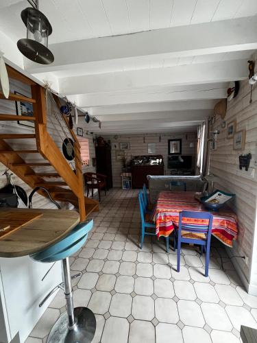 a room with a table and chairs and a couch at Penty bigouden 18ème classé 2** jardin en ville in Pont-lʼAbbé