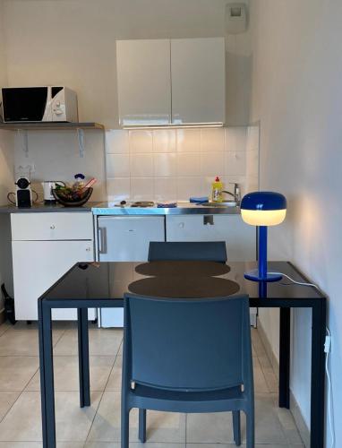 une cuisine avec une table et des chaises dans une cuisine dans l'établissement Studio 25 m2 Tour Black Swans Centre ville Tram C et E direct Parlement Européen à 15 minutes Arrivée 24 sur 24, à Strasbourg