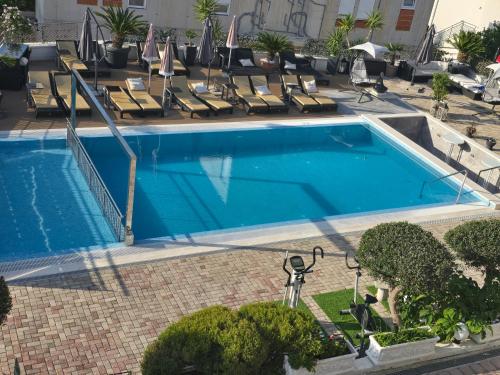 an empty swimming pool with lounge chairs and a hotel at Luxury Apartments Silva with sea view in Trogir