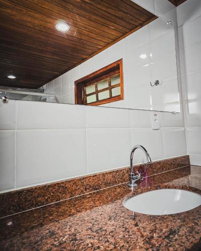 a bathroom with a sink and a window at Pousada Conde Redondo in Lumiar