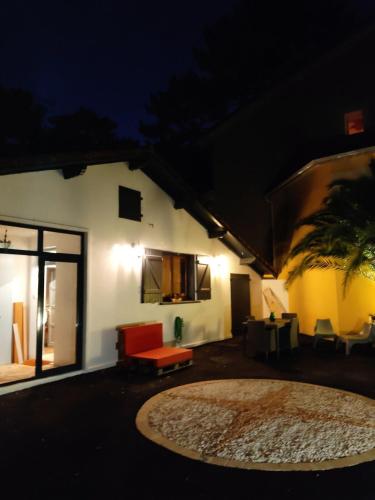 une maison avec une table et des chaises la nuit dans l'établissement Vigie, à Soorts-Hossegor