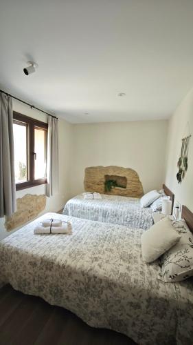 a bedroom with two beds with towels on them at Can Costals Lavanda in Pals