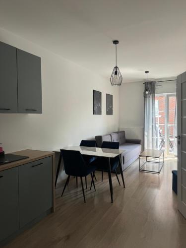 a kitchen and living room with a table and chairs at AboutArtApartments - By the river in Wrocław