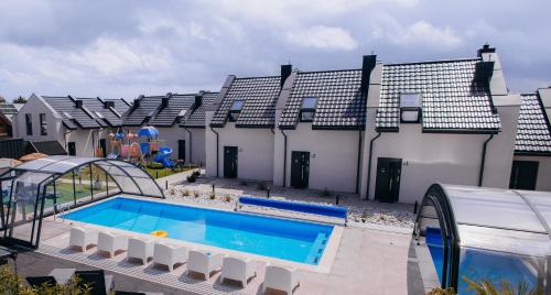 une piscine devant une maison dans l'établissement APARTAMENTY 3 CÓRKI, à Jastrzębia Góra