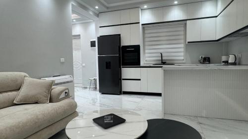 a living room with a couch and a kitchen at Ada Apartment Hilltop Serenity in Durrës