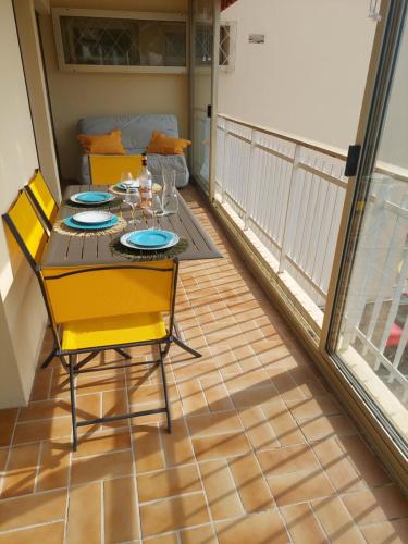 une salle à manger avec une table et des chaises sur un balcon dans l'établissement 54m2, clim, T2, centre BANDOL, terrasse, TOUT A PIED, à Bandol