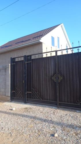 a black gate in front of a house at Частеый дом отдыха in Akchiy