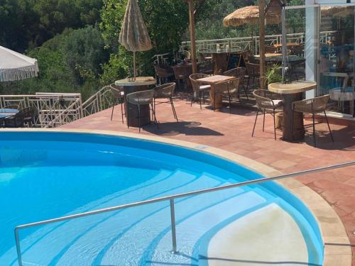 a swimming pool with tables and chairs and a patio at appartement avec jardin privé dans une résidence hôtelière haut de gamme in Vilamoura