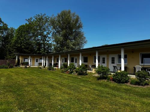 a building with a large yard in front of it at POMERANIA Pokoje U Oliwii in Rewal