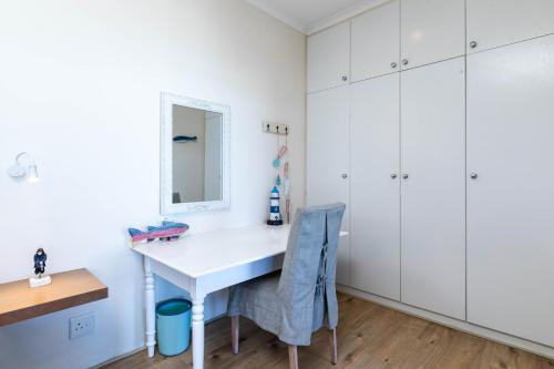 a home office with a white desk and a mirror at Dune Beach House in Wilderness