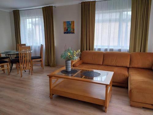a living room with a couch and a table at Saulės miesto apartamentai in Šiauliai