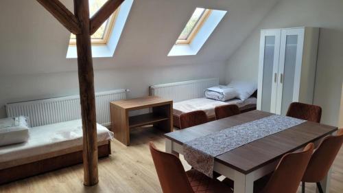 a room with two beds and a table and chairs at Agroturystyka Błądkowo 20A, Dom 11 miejsc in Błądkowo