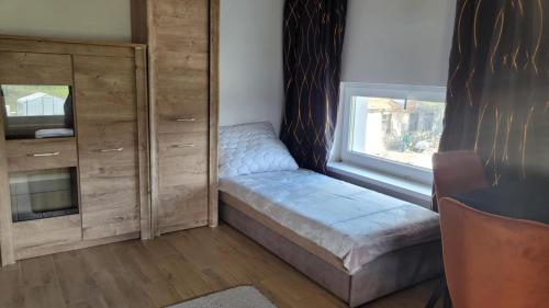 a bedroom with a bed and a dresser and a window at Agroturystyka Błądkowo 20A, Dom 11 miejsc in Błądkowo