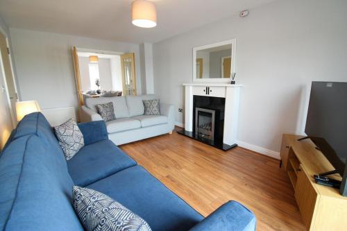 a living room with a blue couch and a fireplace at Luxury Riverside Living in Morton