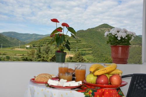 a tray of fruit and juice on a table at Apartament Cela in Çorovodë