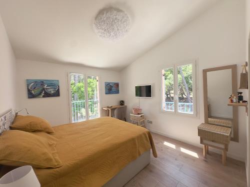 une chambre avec un lit et deux fenêtres dans l'établissement VILLAS Plages de la Nartelle- Sainte Maxime - piscines privées, à Sainte-Maxime
