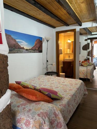 a bedroom with a bed with a painting on the wall at La Trinidad in La Guancha