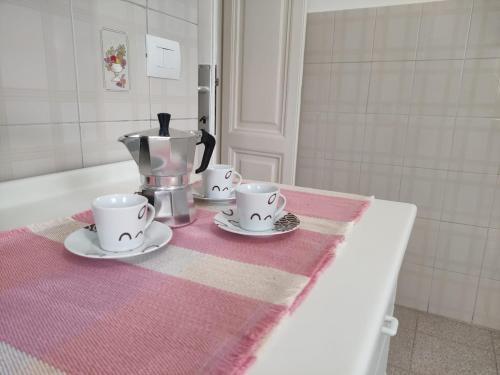 a table with three cups and a coffee maker on it at Rifugio del Quadraro Rome in Rome