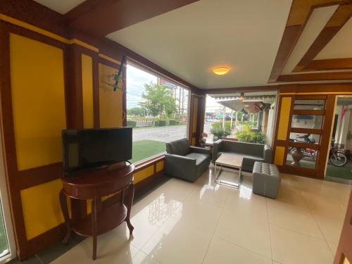 a living room with a flat screen tv and a couch at Kiatnakhon Hotel in Nakhon Si Thammarat