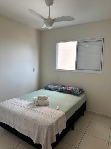 a bedroom with a bed and a ceiling fan at Apartamento Smart in São Carlos