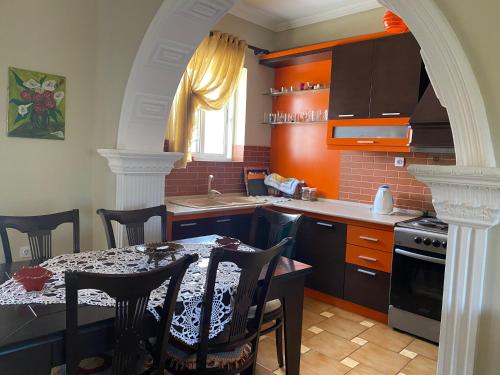 a kitchen with a table with chairs and an archway at Vila Ridvani in Korçë