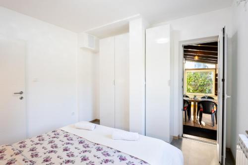 a white bedroom with a bed and a table at Borea Strunjan in Portorož