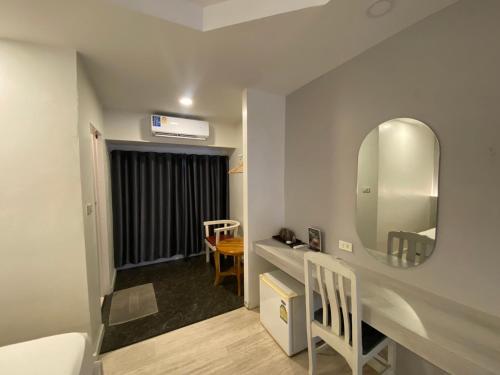 a bathroom with a sink and a mirror on a wall at Kiatnakhon Hotel in Nakhon Si Thammarat