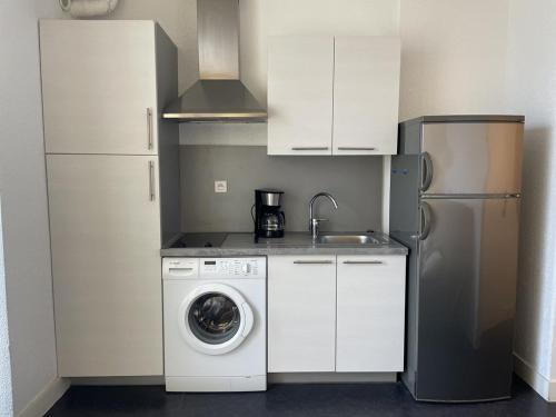 une cuisine avec un lave-linge et un réfrigérateur dans l'établissement Studio Héliopolis E1 - 2 personnes, au Cap d'Agde