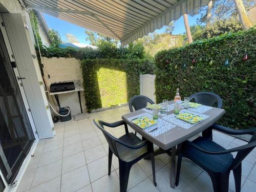 une table et des chaises assises sur une terrasse dans l'établissement Maisonnette avec terrasse à 300m de la plage 2 étoiles, à Saint-Georges-de-Didonne