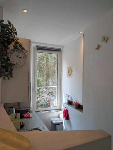une cuisine avec une fenêtre et une horloge murale dans l'établissement Appartement - Cannes vieille ville - Le Suquet, à Cannes