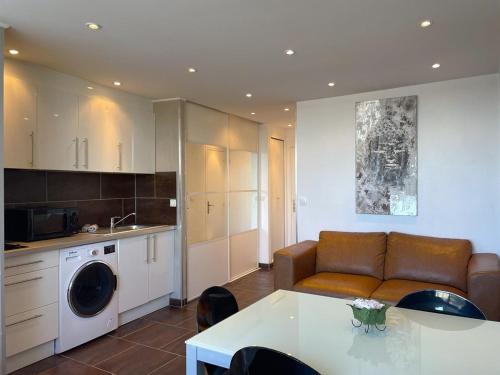 un salon avec un canapé et une cuisine dans l'établissement Studio BROWN Héliopolis D 29 - Luxe - 2 personnes, au Cap d'Agde