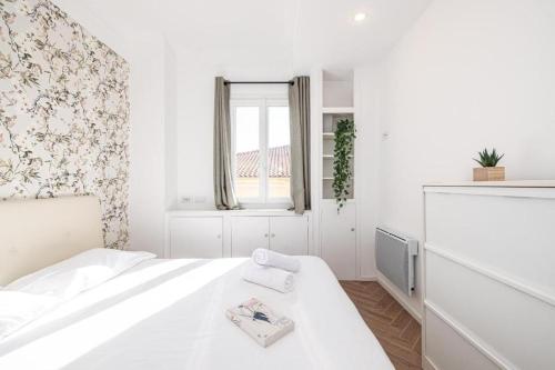 une chambre blanche avec un lit et une fenêtre dans l'établissement Saint Charles, à Menton