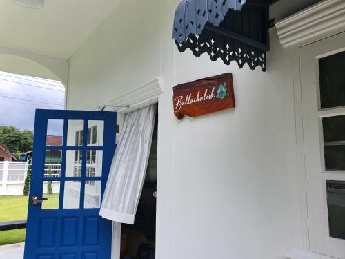 a blue door and a sign on a house at Ballachulish Rayong 2 BR in Mae Pim