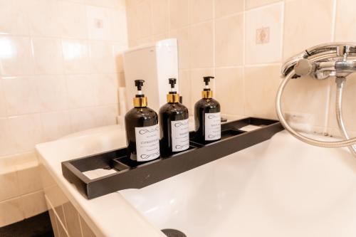 three bottles of wine sitting on top of a bath tub at M House Ruhiges Einzelzimmer mit Privatsphäre für 1-2 Personen in Hagen