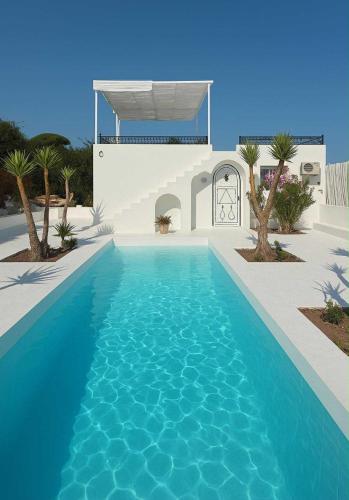 a blue swimming pool in front of a house at Villa Brise du Golfe Hammamet in Hammamet