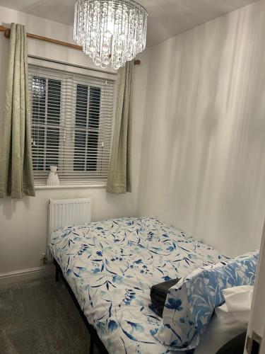 a bedroom with a bed and a chandelier at 3BR House in Newton-Le-Willows - Sleeps 6 in Earlestown