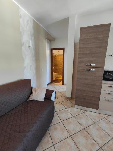 a living room with a couch and a kitchen at Daisy House in Acilia