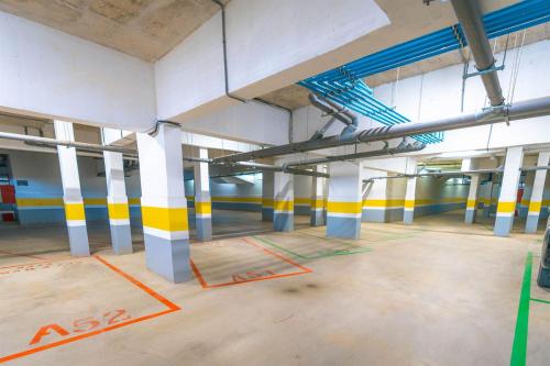 an empty parking lot with yellow and white columns at appartement costa mar martil avec piscine in Martil
